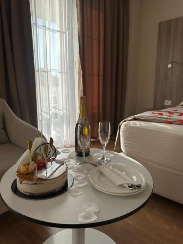 a table with a cake and a bottle of wine at Kompleksi Exalco-Al in Shkodër