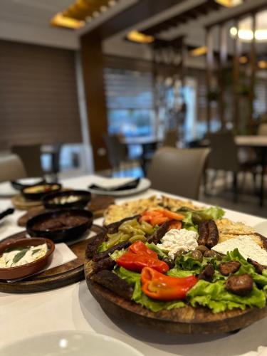 a table topped with a pizza with vegetables on it at Kompleksi Exalco-Al in Shkodër