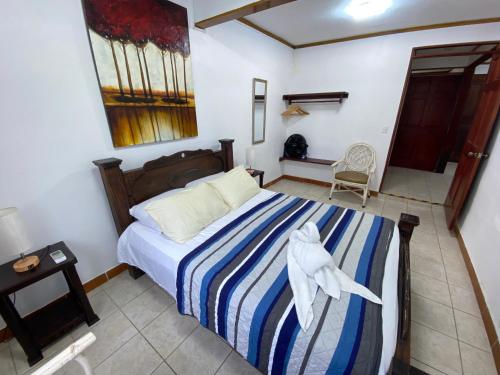 a bedroom with a bed with a blue and white striped blanket at Apto Cielo Azul in Manuel Antonio