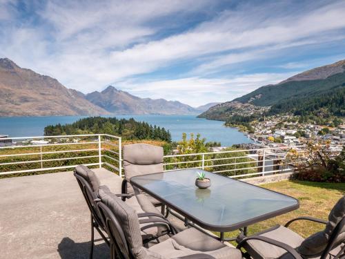 a table and chairs on a patio with a view of a lake at The view of Queenstown in Queenstown
