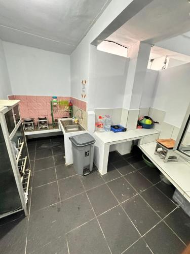 a kitchen with white counters and a sink in it at Ambon Residence Syariah in Ambon