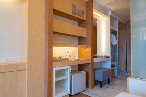 a room with a wall with shelves and a chair at Khum Phucome Hotel -SHA Extra Plus in Chiang Mai