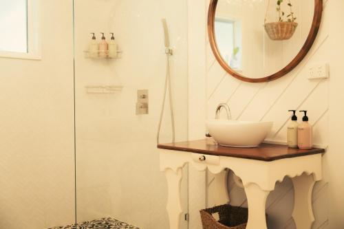 a bathroom with a sink and a mirror at Over The Road in South Bingera