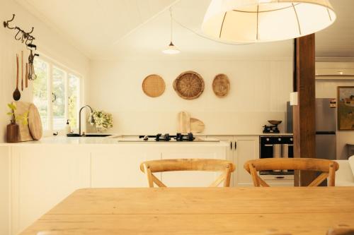 a kitchen with a wooden table and two chairs at Over The Road in South Bingera