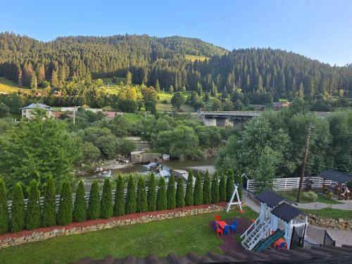 a view of a park with a river and a playground at Pensiunea Ioana in Sadova