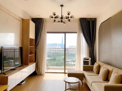 a living room with a couch and a large window at The Sun Avenue Serviced Apartment in Ho Chi Minh City