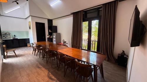 a dining room with a large wooden table and chairs at MAI Villa Da Nang in Da Nang