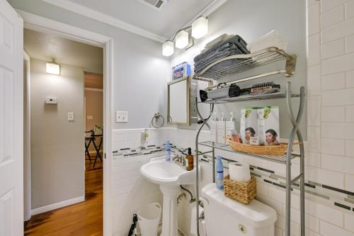 a white bathroom with a sink and a toilet at The Homestead Apartments- Walk to SFA Campus, Comfy, Children & Pet-Friendly Nacogdoches Condo in Nacogdoches