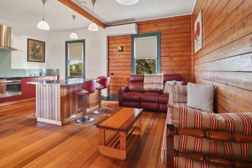a living room with a couch and a table at The Settlers Cottage - In the Heart of St Helens in St Helens