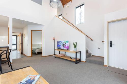 a living room with a table and a room with a bed at Central Methven Chalet, 3 Bedroom, Family Friendly in Methven