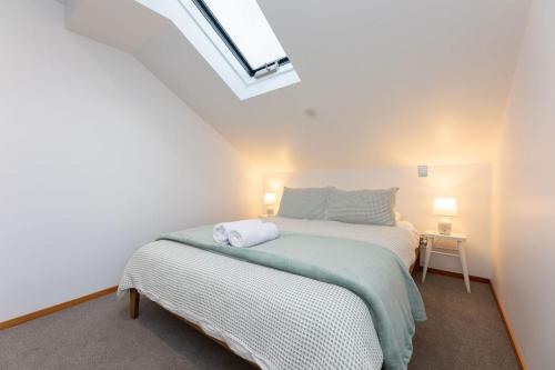 a bedroom with a bed and a skylight at Central Methven Chalet, 3 Bedroom, Family Friendly in Methven