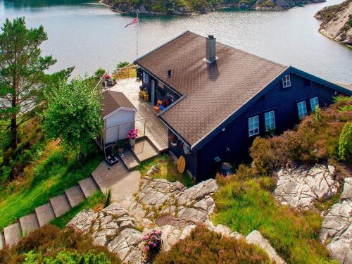 an aerial view of a blue house on the water at 6 person holiday home in Urangsvåg in Steinsbø