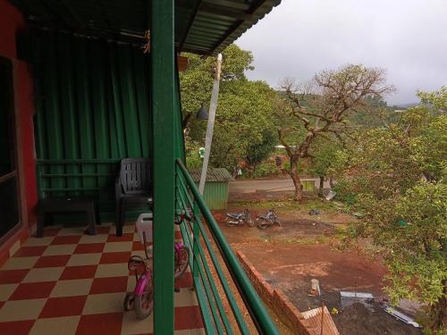 a green porch with bikes parked on a checkered floor at The Grand Rooma Home stay 003 in Mahabaleshwar