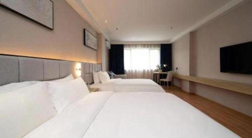 a large bedroom with two beds and a flat screen tv at danfeng kelly hotel in Shenzhen