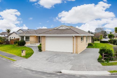 a house with a garage on a driveway at Spacious Holiday Home in a Superb Location in Auckland