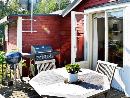 a patio with a grill and a table and chairs at 4 person holiday home in SÖLVESBORG in Björkenäs