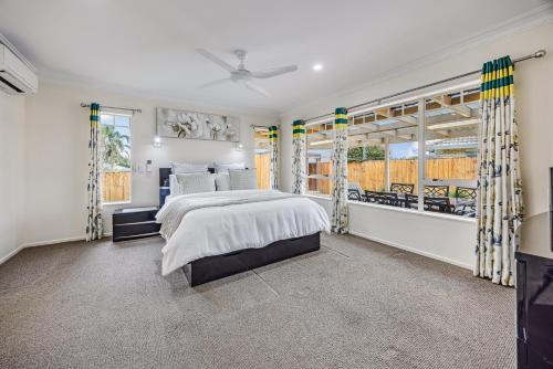 a bedroom with a large bed and windows at Spacious Holiday Home in a Superb Location in Auckland