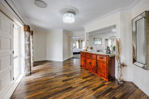 a bathroom with a wooden vanity and a mirror at Spacious Holiday Home in a Superb Location in Auckland