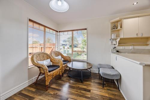 a kitchen with wicker chairs and a table in a room at Spacious Holiday Home in a Superb Location in Auckland