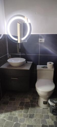a bathroom with a toilet and a sink and a light at Manta departamento rústico y lujo in Manta