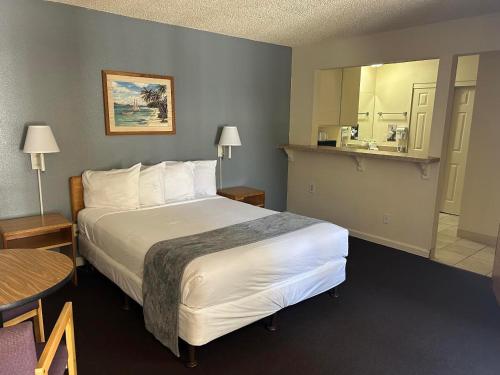 a hotel room with a large bed and a bathroom at California Suites Hotel in San Diego