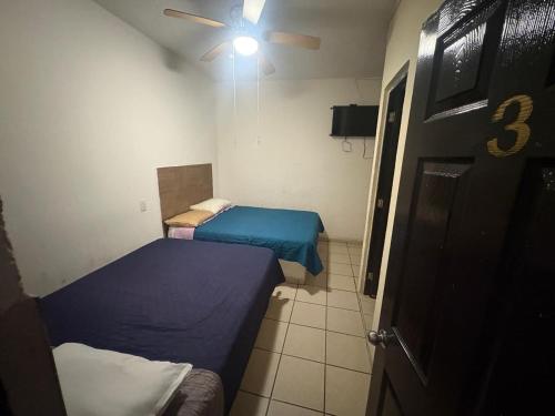 a room with two beds and a ceiling fan at Hospedaje Ferchitos in Sofía