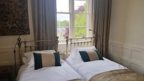 two beds in a bedroom with a window at Appleby Castle in Appleby