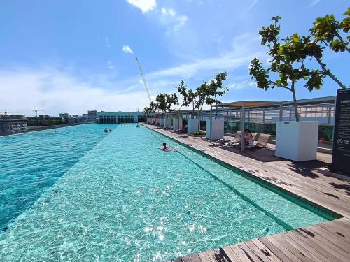 a large swimming pool with people in the water at SUTERA AVENUE 2BEDROOM B8 by GC near imago kk in Kota Kinabalu