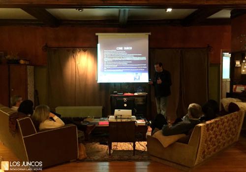 a man giving a presentation in front of a screen at Los Juncos Patagonian Lake House in San Carlos de Bariloche