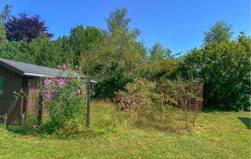 a garden with pink flowers and a fence at 2 Bedroom Awesome Home In Melby in Melby