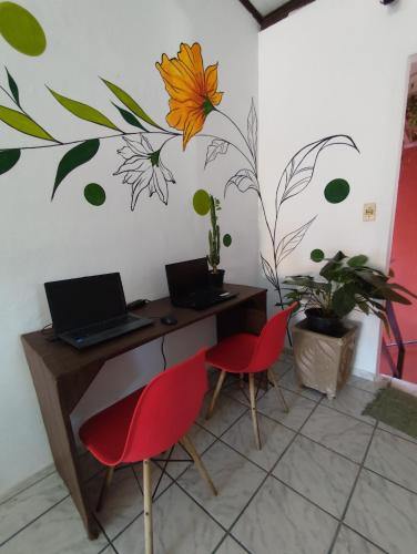 a room with a desk with a laptop and two chairs at Pousada Ray Sol - Centro Arraial d Ajuda in Arraial d'Ajuda