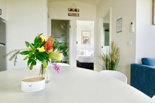a white table with a vase of flowers on it at BIG4 Wilsons Prom Holiday Park in Yanakie