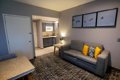 a living room with a couch and a kitchen at voco Saltillo Suites by IHG in Saltillo