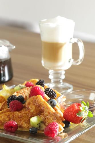 a plate of food with fruit and a cup of coffee at voco Saltillo Suites by IHG in Saltillo