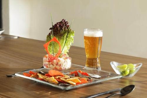 a tray of food and a glass of beer on a table at voco Saltillo Suites by IHG in Saltillo