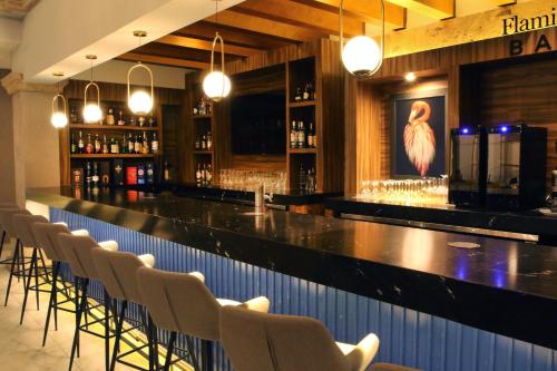 a bar with a row of chairs in a restaurant at voco Saltillo Suites by IHG in Saltillo