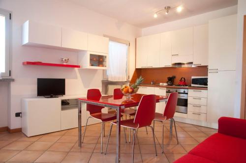 a kitchen with a dining room table and red chairs at Ca' Eli 2 in Oliveto Lario