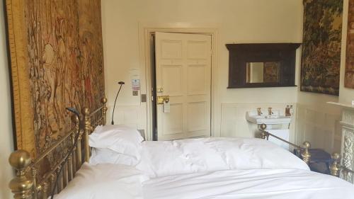 a bedroom with a bed with white sheets at Appleby Castle in Appleby