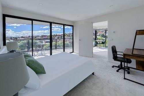 a bedroom with a white bed and a desk and a desk at 4 bedrooms luxury Sea View Family retreat in Sandy bay in Hobart