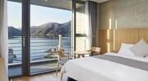 a bedroom with a large window with a view of a lake at Hotel Haus in Gapyeong