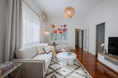 a living room with a couch and a table at Lux 4B Queenslander by The Gabba in Brisbane