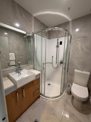a bathroom with a shower and a toilet and a sink at Goodview Hotel in Auckland