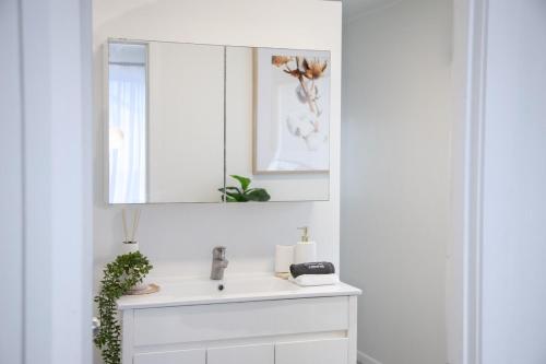 a bathroom with a sink and a mirror at Lux 4B Queenslander by The Gabba in Brisbane