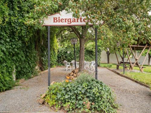 a sign for a garden with a table and chairs at Cozy Family Apartment in Braunichswalde
