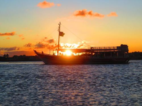 a boat sitting in the water at sunset at Pousada Ray Sol - Centro Arraial d Ajuda in Arraial d'Ajuda