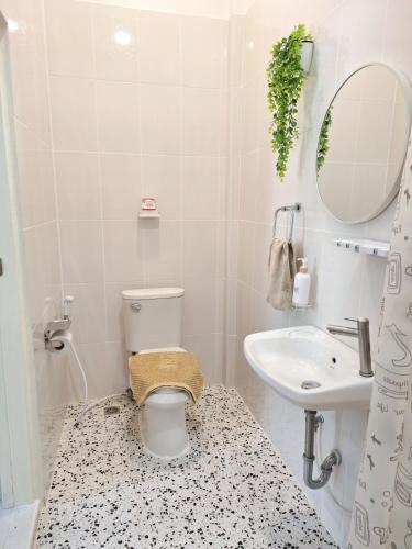a bathroom with a toilet and a sink and a mirror at ธัญพร เกสต์เฮาส์ in Tak