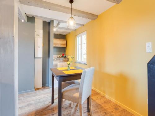 a dining room with yellow walls and a table and chairs at Apartment in Alsace near Haut-Koenigsbourg in Dambach-la-Ville