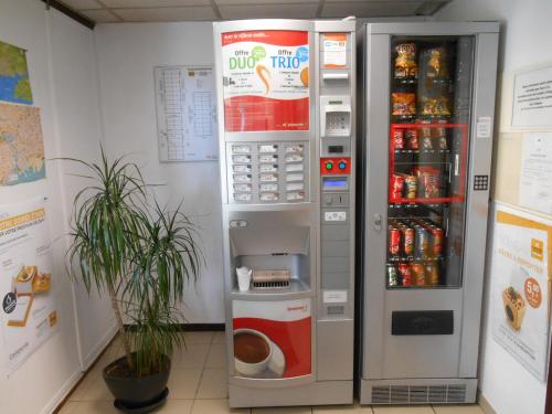 a coca cola vending machine with a drink inside at Premiere Classe Brest Gouesnou Aeroport in Gouesnou