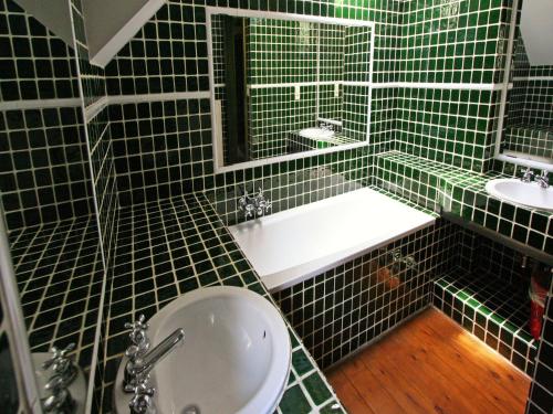a green tiled bathroom with a toilet and a sink at Mansion with Pool, Néblon in Ouffet
