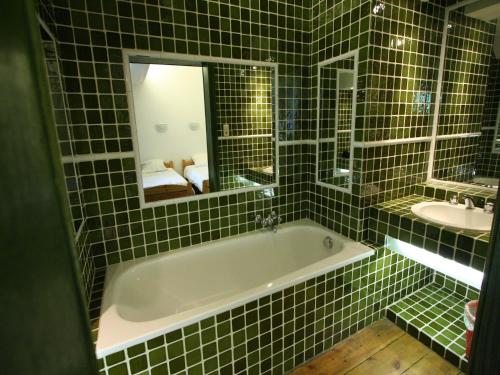 a green tiled bathroom with a tub and a sink at Mansion with Pool, Néblon in Ouffet